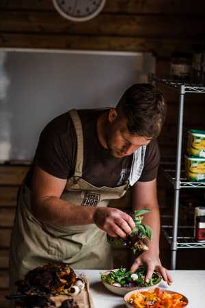 Chef frying scallops in a pan with fine herbs