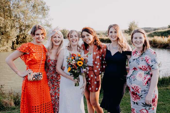 bride holding a bouquet standing with bridesmaids