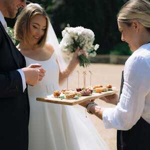 brinde and groom eating from a canape board | Photo credit: Courtney Marie Photographer