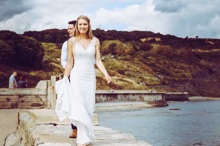 bride walking along harbour wall