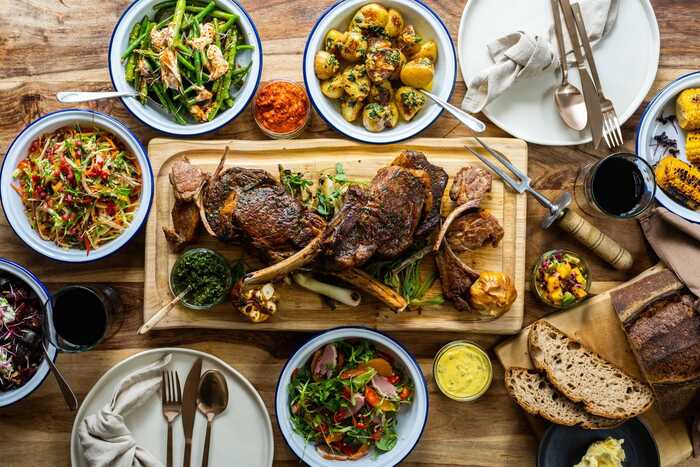 top down image of a food table including meat salads and breads